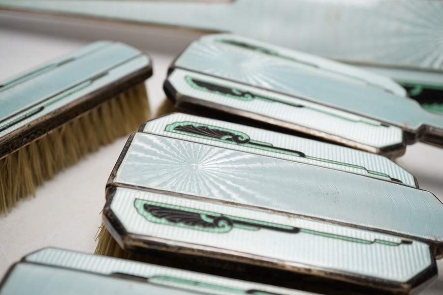 An Art Deco silver and enamel five piece dressing table set, by Adie Bros Ltd, Birmingham 1934, hand mirror 31.5cm long. Condition - small losses to enamels otherwise fair